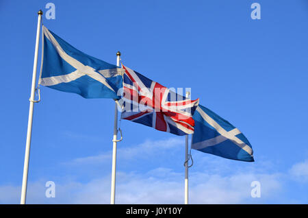 Sautoires écossais et l'union flag voler côte à côte contre un ciel bleu (photo) Banque D'Images