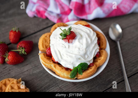 Rouge frais fraises et crème fouettée sur une gaufre d'or Banque D'Images