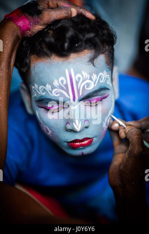 Jeune homme ayant son visage peint à l'Bédeille et charak festival en Krishnadepur, West Bengal Banque D'Images