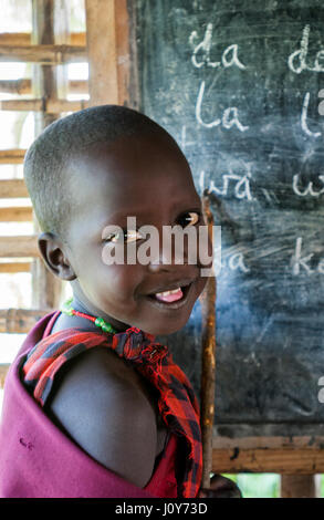 Jeune élève de Maasai souriant devant le tableau noir à L'école du village apprendre l'anglais Banque D'Images