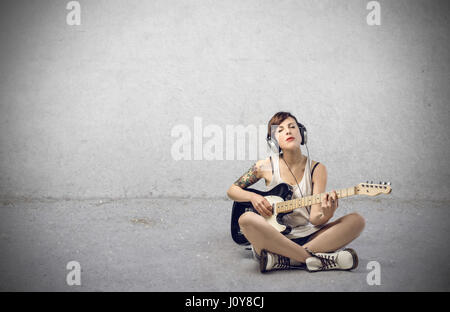 Grunge femme jouant sur une guitare électrique Banque D'Images