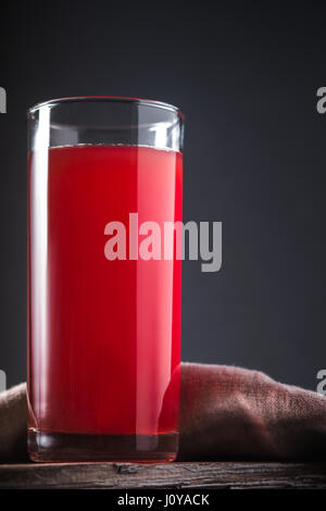 Boissons à base de canneberge dans un grand verre sur fond gris à la verticale Banque D'Images