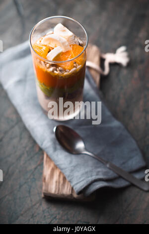 Smoothie sain avec la banane, l'pampkin, d'avocat et de graines de lin dans un verre bouteilles sur une verticale de fond rustique Banque D'Images