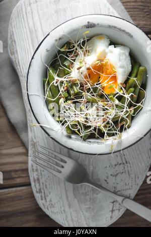 Salade avec des haricots germés, le lin et les œufs de caille dans un bol en métal et verticale de la fourche Banque D'Images