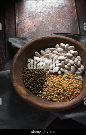 Placer les haricots verts et blancs dans un bol en bois à la verticale Banque D'Images