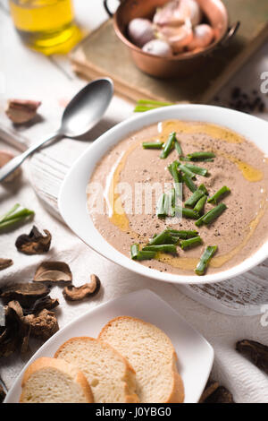 Crème de champignons soupe sur la verticale de fond en bois blanc Banque D'Images