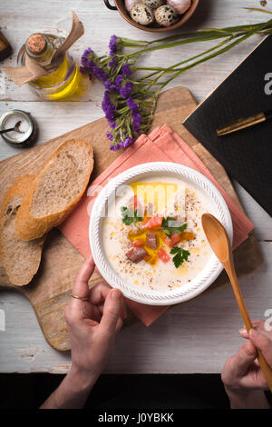 Femme mangeant purée soupe avec les saumons d'un bol en céramique Banque D'Images