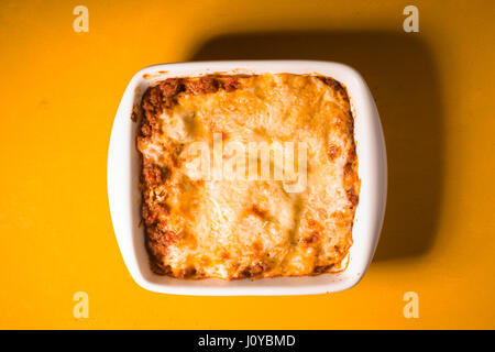 Lasagne à la viande fait maison en bois sur table jaune Banque D'Images