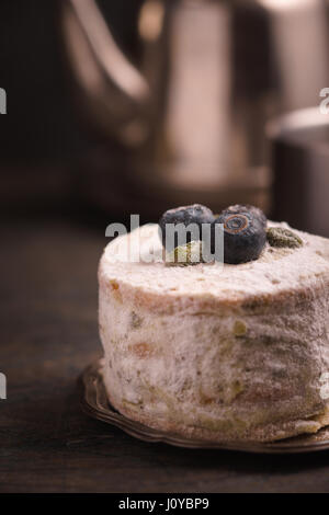 Cake aux myrtilles et pistaches contre une théière Banque D'Images