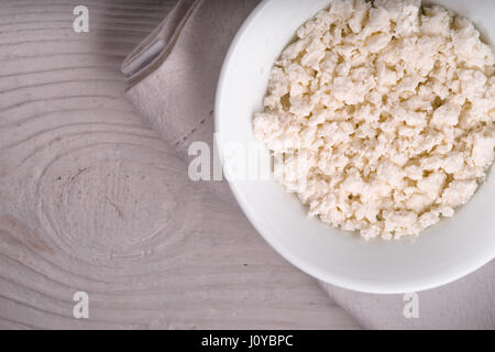 Le fromage blanc dans un bol en céramique sur une serviette blanche diagonale Banque D'Images