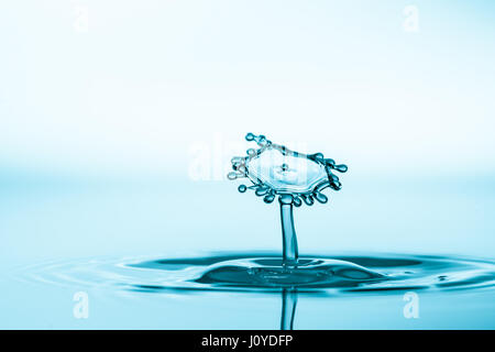 Les éclaboussures d'eau isolé sur fond bleu. Goutte d'eau. Collision de deux gouttes d'eau Banque D'Images