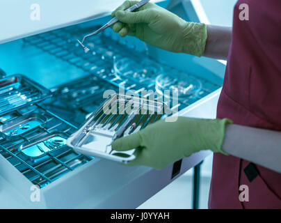 Dentiste mains tenant des instruments dentaires Banque D'Images