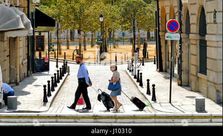 Paris, France. Ile de la Cite. Place Dauphine vu de Rue Henri-Robert. Couple wheeling assurance Banque D'Images