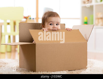 Joli bébé Bébé garçon assis à l'intérieur d'une boîte Banque D'Images