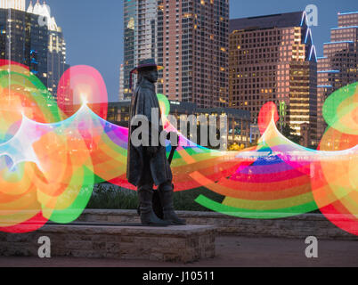 Statue de Stevie Ray Vaughan dans la nuit sur le lac Lady Bird avec un arc-en-ciel lumineux en arrière-plan Banque D'Images