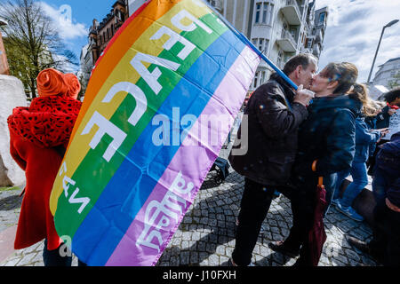 Hambourg, Allemagne. Apr 17, 2017. Quelques baisers sous un drapeau arc-en-ciel avec le mot "paix" écrit en plusieurs langues, au cours de mars du printemps de cette année par le mouvement de paix à Hambourg, 17 avril 2017. Photo : Markus Scholz/dpa dpa : Crédit photo alliance/Alamy Live News Banque D'Images