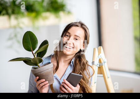 Femme avec téléphone et cache-pot Banque D'Images