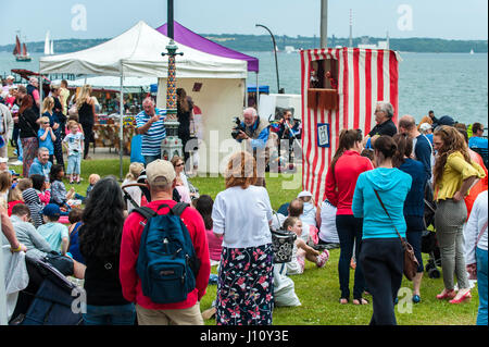 Punch et Judy spectacle de marionnettes avec les adultes et les enfants à regarder dans la promenade Park, Cobh, Irlande avec copie espace. Banque D'Images