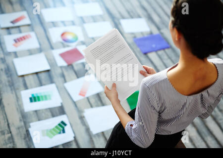 Les jeunes avec des papiers de couleur le choix du décorateur pour le projet Banque D'Images