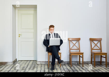 Portrait of young businessman using laptop in salle d'attente à l'extérieur du bureau Banque D'Images