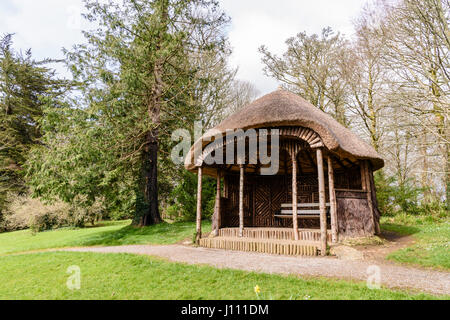 Toit d'une maison en bois avec un toit de chaume dans un jardin. Banque D'Images