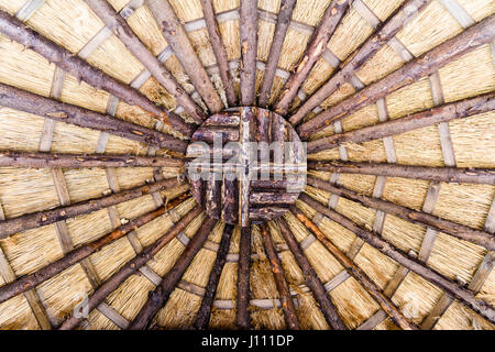 Toit d'une maison en bois avec un toit de chaume dans un jardin. Banque D'Images