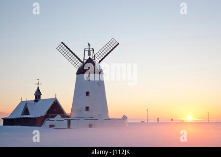 Le moulin blanc à Lytham St Annes au coucher du soleil, avec de la neige au sol. Banque D'Images