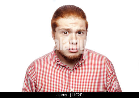 Surpris choqué readhead barbu businessman avec chemise rouge et de rousseur looking at camera. studio shot isolé sur blanc. Banque D'Images