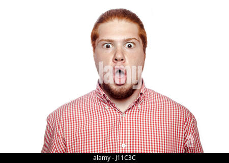 Surpris choqué readhead barbu businessman avec chemise rouge et de rousseur looking at camera. studio shot isolé sur blanc. Banque D'Images