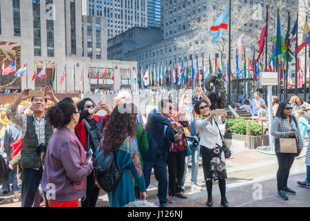 Des hordes de touristes affluent pour le Rockefeller Center de New York le Vendredi saint, le 14 avril 2017 pour profiter des milliers de fleurs décorant les Channel Gardens. NYC & Co, l'Agence du tourisme de la ville, a prévu que New York recevra moins de 300 000 visiteurs d'outre-mer en 2017, la première baisse depuis 2008. Les visiteurs étrangers dépensent près de la moitié des 42 milliards de dollars que la ville tire en tourisme. (© Richard B. Levine) Banque D'Images