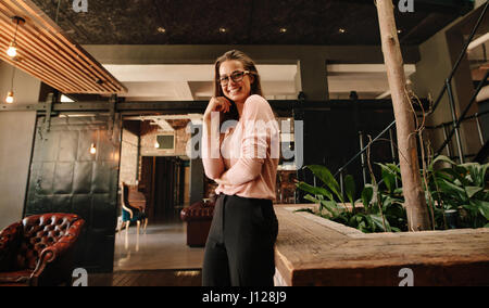 Portrait de la belle jeune femme à la caméra et au sourire. Business Woman in office lobby à heureux. Banque D'Images