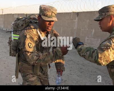 Les soldats de la 29th us Infantry Division a mené un 12-mile ruck mars pour être admissible à l'École d'assaut aérien au Camp Arifjan, au Koweït le 11 février 2017. L'Adjudant-chef 2 Écran Felton mains une carte pour son année d'avoir son temps enregistrés comme il a franchi la ligne d'arrivée. Les meilleurs concurrents représenteront la Division à l'assaut aérien de 10 jours avec l'école l'occasion de gagner l'United States Army Air Assault Badge. (U.S. Photo de l'armée par le sergent. Francis O'Brien/libérés) Banque D'Images