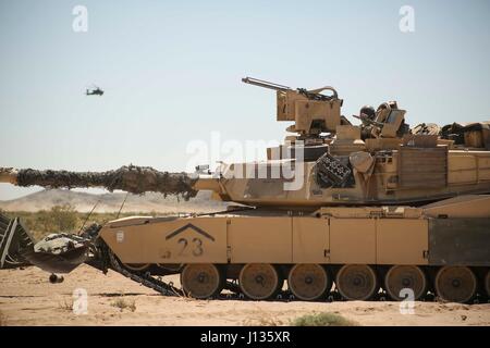 Des soldats américains, affecté à la 1ère Brigade Combat Team, 3e Division d'infanterie, regarder un hélicoptère d'attaque AH-64 Apache à partir de leur réservoir d'Abrams, au cours de l'action décisive 17-05 Rotation au Centre National d'entraînement à Fort Irwin, en Californie, Avril 03, 2017. (U.S. Photo de l'armée par la CPS. Sacharok JD, Operations Group, National Training Center) Banque D'Images