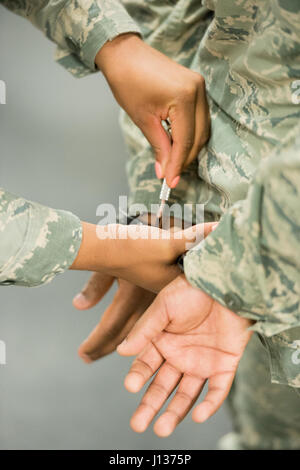 Les membres du 436e escadron des forces de sécurité de la base aérienne de Douvres pratiquent des techniques de menottage conçues pour assurer la sécurité des officiers et minimiser les risques pour les suspects pendant les opérations de répression. Banque D'Images