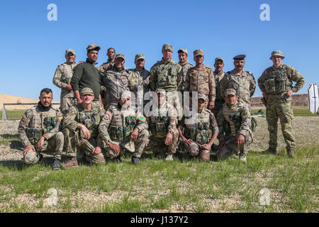 Formateurs britanniques déployées à l'appui de la Force opérationnelle interarmées combinée - Fonctionnement résoudre inhérent et affecté à l'Highlanders, 4e Bataillon, The Royal Regiment of Scotland (4) Sylvestre et les forces de sécurité irakiennes militaires prennent une photo de groupe lors d'un entraînement aux armes à Al Asad Air Base, l'Iraq, le 8 avril 2017. Cette formation fait partie de l'ensemble de la CJTF OIR - renforcer les capacités des partenaires mission de former et d'améliorer la capacité des forces des combats en partenariat avec ISIS. Les GFIM - OIR est la Coalition mondiale pour vaincre ISIS en Iraq et en Syrie. (U.S. Photo de l'armée par le Sgt. Lisa soja) Banque D'Images