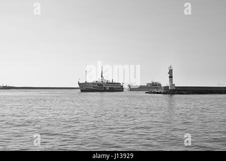 La photographie en noir et blanc traditionnel de ferry public arrivant à la gare de Kadikoy. Disjoncteur d'eau et un bateau à moteur sont également dans la vue. Banque D'Images