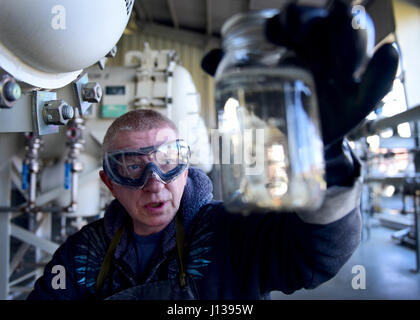 Darryl Hodge, 733e Escadron de préparation logistique des systèmes de distribution de carburants fossiles installations, l'exploitant prend un échantillon de carburant au joint Base Langley-Eustis, en Virginie, le 10 avril 2017. En plus de son impact sur les opérations aériennes, les carburants des véhicules du gouvernement d'assurer également des installations sur la base sont fournis avec du carburant et les bâtiments sont fournis avec de nombreux produits du sol qu'ils ont besoin, y compris l'essence, le diesel à faible teneur en soufre standard et le biodiesel, qui est plus respectueux de l'environnement. (U.S. Air Force photo/Le s.. Areca T. Bell) Banque D'Images