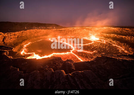 Région Afar, Ethiopie : les visiteurs se tenir autour du bord de la lac de lave. Avez-vous déjà demandé ce qu'il doit ressembler à regarder dans les profondeurs de l'enfer ? Photos de l'intérieur d'un 150 pieds de large volcan basalte active continuellement prouver que certaines parties de la planète ne ressemble à l'enfer sur terre. Karel photographe Tupy (35) visité le plus ancien lac de lave active en permanence, Erta Ale en Ethiopie qui est l'un des six lacs de lave dans le monde. Banque D'Images