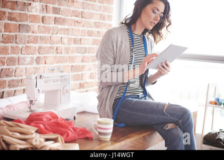 Femme propriétaire using digital tablet Banque D'Images