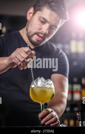 Barman est en remuant des cocktails sur comptoir bar Banque D'Images