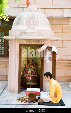 La lecture de l'homme saint livre en face de temple de Hanuman, Mathura, Uttar Pradesh, Inde, Asie Banque D'Images