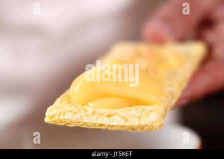 La diffusion de la mayonnaise sur le maïs croustillant. Faire de la mayonnaise avec une cuillère en bois. Banque D'Images