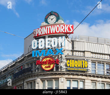 De l'extérieur de divertissement Printworks, dans le centre-ville de Manchester center, montrant tous les logos publicitaires colorés contre un ciel bleu. Banque D'Images