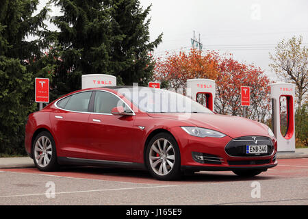 PAIMIO, FINLANDE - le 14 octobre 2016 : Rouge berline de luxe de Tesla Model S est en charge chez Tesla Supercharger. Banque D'Images