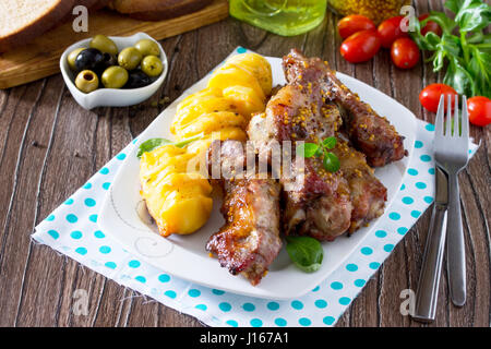 Hacher de la viande marinée, avec du miel et de la moutarde avec des pommes de terre au four. Banque D'Images