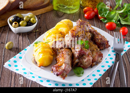 Hacher de la viande marinée, avec du miel et de la moutarde avec des pommes de terre au four. Banque D'Images