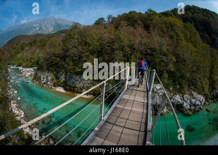 Une des promenades en vélo de montagne à travers un pont de bois sur la rivière Soca en Slovénie, l'Europe. Banque D'Images