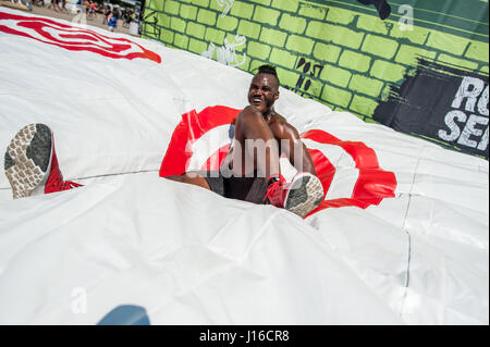 Parcours extrême Tough Mudder est venu de New York ont obtenu les habitants se balançant dans l'action. À partir de la pendaison sur monkey bars et de saut d'obstacles à la prise d'un gel plongent dans l'eau glacée et tombant sur des tapis de crash photos montrent à quel point cet événement amusant encore urbain peut être. Détenu à Randall's Island NYC L'événement comprenait la nourriture, de la musique et de boire pour récompenser les participants épuisés lorsqu'ils ont atteint la fin de leur cours. Banque D'Images