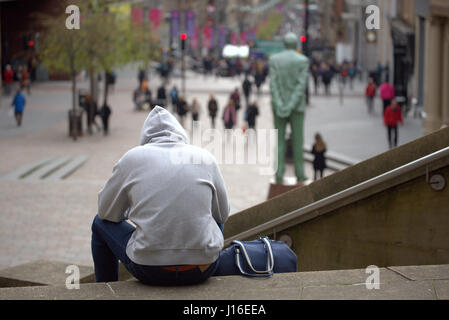 Jeune homme sweats sac de sport de Sport de s'asseoir sur le Glasgow concert hall comme suit à la jonction de Buchanan Street et Sauchiehall Street Banque D'Images