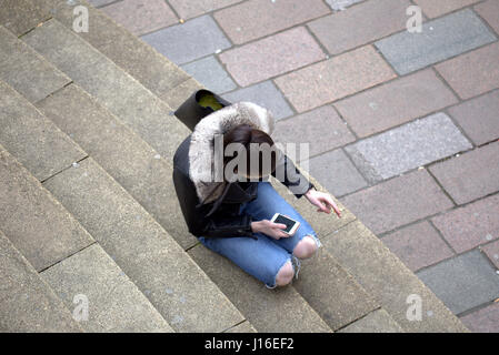 Jeune fille femme de s'asseoir et de fumer pendant l'utilisation de téléphone mobile Glasgow concert hall comme suit à la jonction de la rue Buchanan Sauchiehall Street Banque D'Images